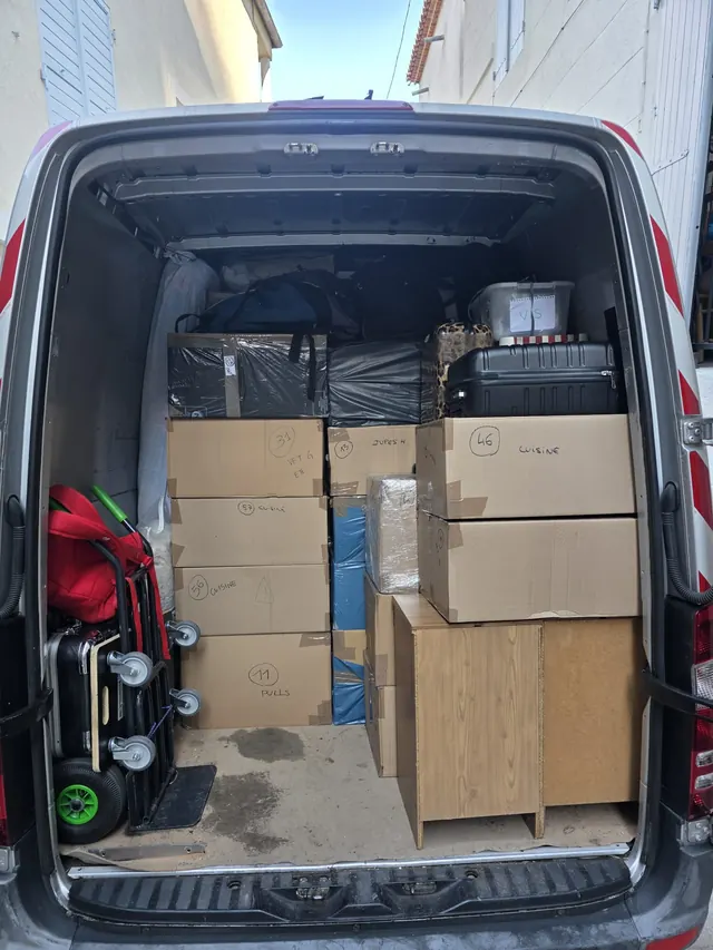 Boxes labelled by room and furniture secured in the van